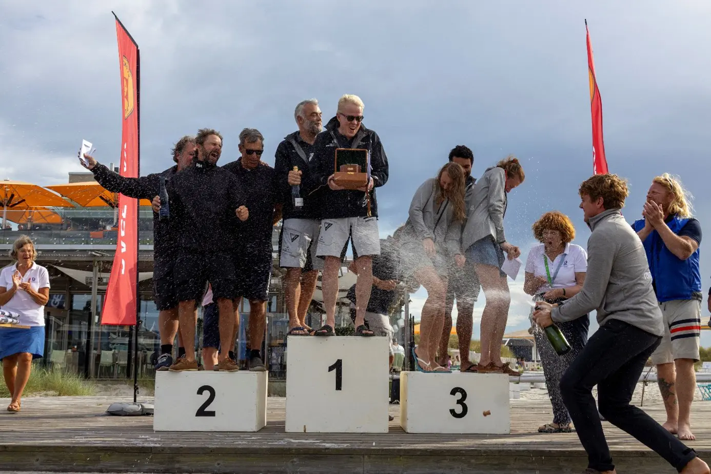En av de unga treorna på SM sprutar på bubbel både på Jan Secher och hans besättning från den svenska mästarbåten, de egna kompisarna och Gunnel Nilsson i organisationskommittén (Foto: Max Klintman för Skanörs Båtklubb).